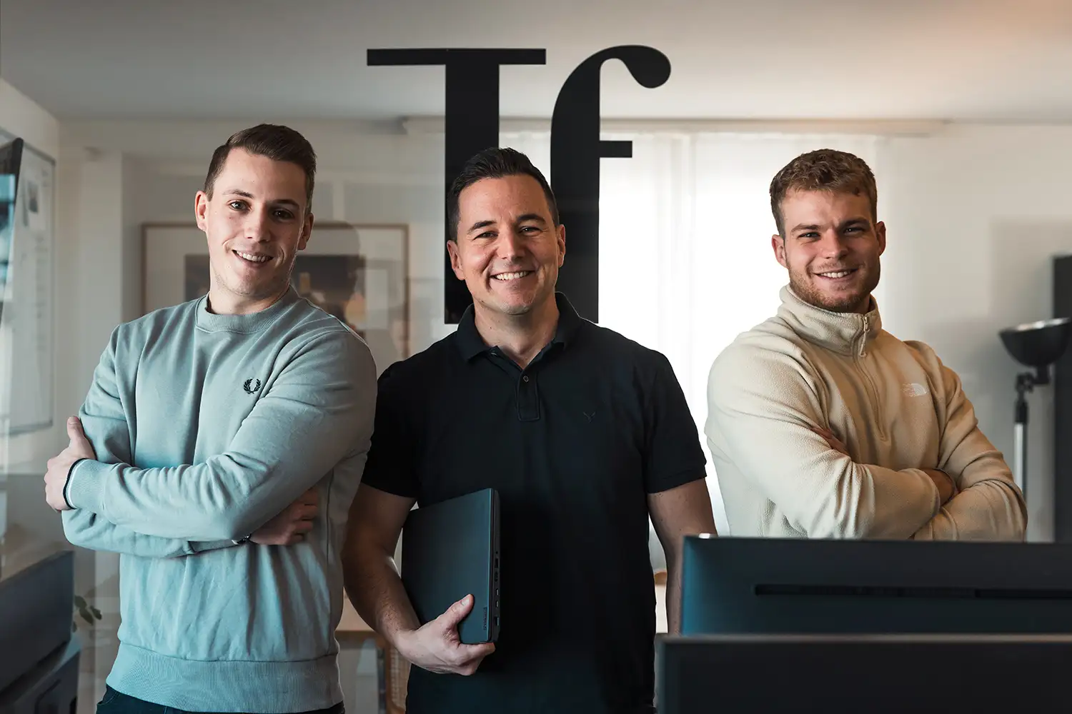 Team Werbeagentur Talfrisch mit Tf Logo im Hintergrund