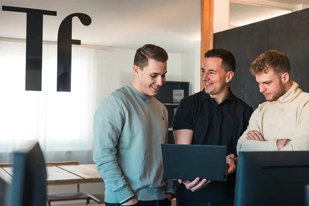 Team Werbeagentur Talfrisch mit Tf Logo im Hintergrund